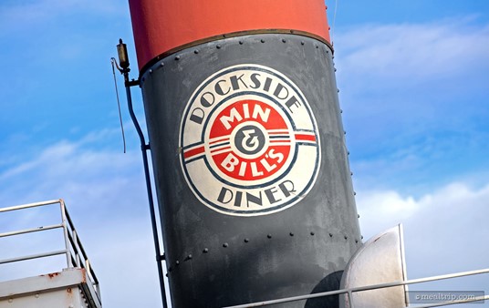This Min & Bill's Dockside Diner logo appears on a smoke stack on the boat, above the front counter.