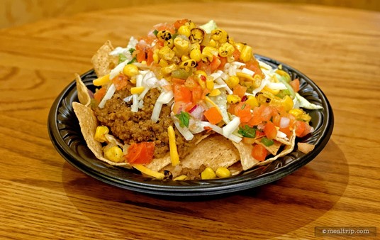 A closer inspection of the Beef Nachos at Pecos Bill's. The "nachos" feature the tortilla chips and are topped with seasoned ground beef, tomatoes and lettuce. The roasted corn, tomato salsa, two shredded cheeses, and sour cream were added at the toppings bar.