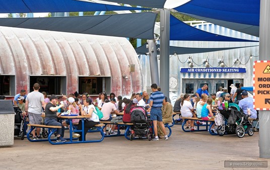 There's a covered seating area just outside the payment registers at Expedition Cafe. Based on the partially visible sign on the right, if you 'mobile ordered' food, you can just skip the main entrance line and pick up your food by way of the side entrance..