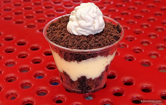 A Vanilla Pudding Cup with Chocolate Crumbles and Whipped Cream.