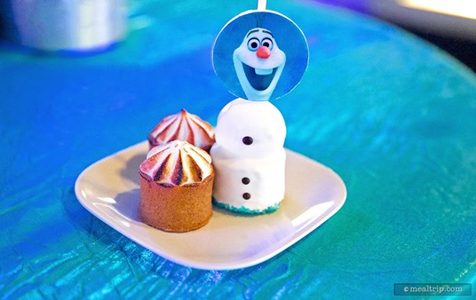 Here, an Olaf Carrot Cheesecake Snowman on a Stick sits with a couple Key Lime Tarts.