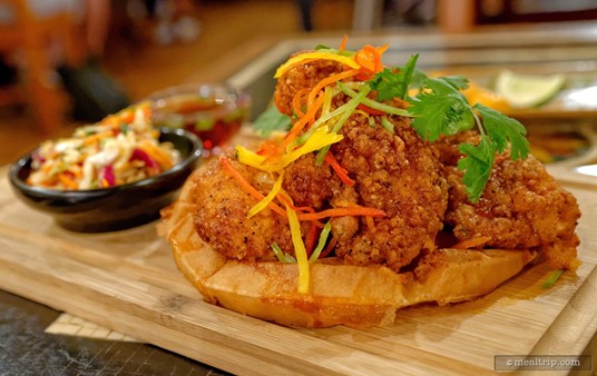 The Korean Fried Chicken & Waffle from Yak and Yeti features Hand battered chicken, buttermilk waffle, gochujang maple syrup and kimchi slaw.