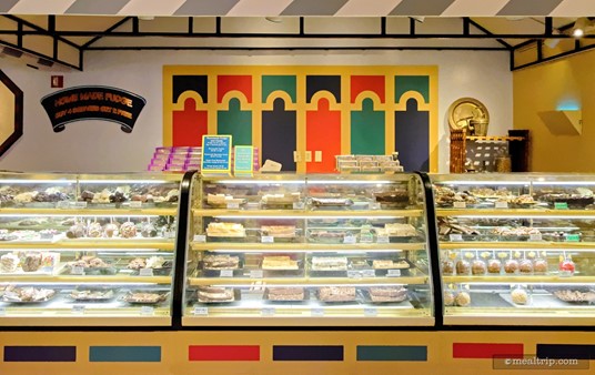 There are several counters like the one pictured here, displaying baked goods, confections, and dipped candy apples.