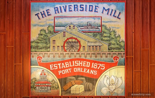 This great art piece painted on wood is hanging on an interior wall and high in the rafters at the Riverside Mill Food Court.