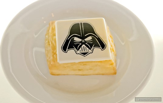 Darth Vader's Vanilla Cream Turnover... "turnover" to the dark side! Okay, the theming is kind of thin, but the vanilla cream turnover was quite tasty. The turnover combined fresh, flaky layers of pastry filled with a "not too sweet" thick vanilla cream, and topped with a screen printed white chocolate Darth Vader square.