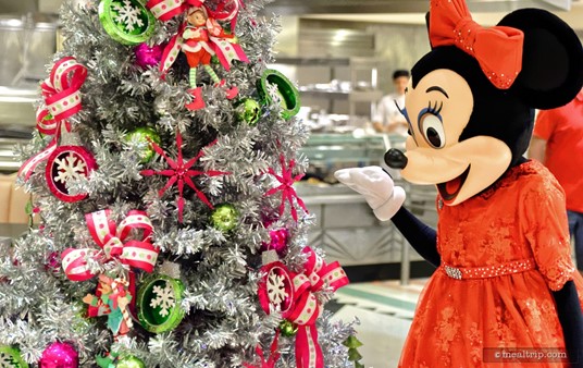 Always the gracious host, Minnie takes a second out of her busy schedule to spruce up the silver tree.