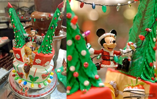 I think Mickey was trying to string the tree with lights, and somehow ended up slitting the cake centerpiece right down the center! I especially like that the cake seems to be filled with even more desserts!