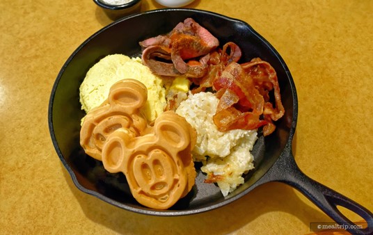 Here's a look at the "warm items" skillet at Garden Grill. So after the "first course" of fruit and cinnamon bread — the second main course is served in this black (plastic) skillet, and contains all the warm items, bunched together.