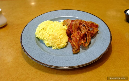 The gray/blue plates on each table are for plating your own portions — as taken from the larger "family style" skillet that's brought to your table. Pictured here are the Scrambled Eggs and Smoked Bacon.