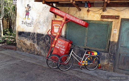 A bike and a refreshment cart are parked just outside the Harambe Market. (Somehow, they have glued these things in place so they don't move at all.)