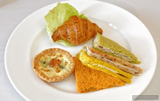 The second of three light courses was a plate that combined four "cold" sandwich halves with two "warm" items, a small quiche and a croissant.