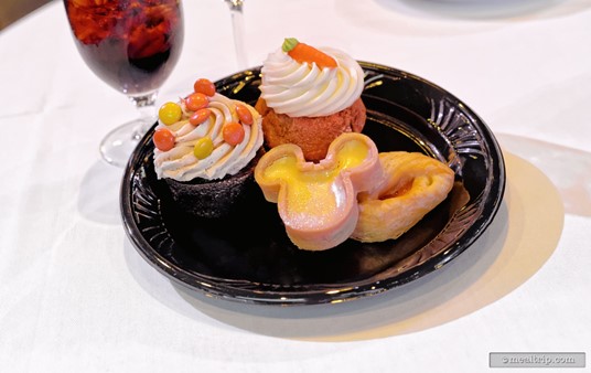 The Mickey shaped dessert in front is a lemon tart. The tart has been dusted with glittering sugar crystals.