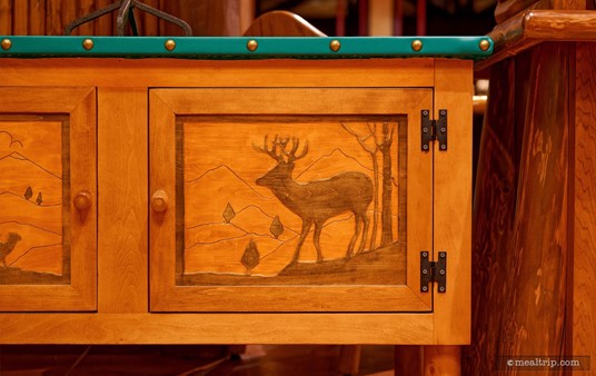 This piece of art is on a cabinet door at Whipsering Canyon Cafe. It's a broad stroke relief carving with various wood stained elements.