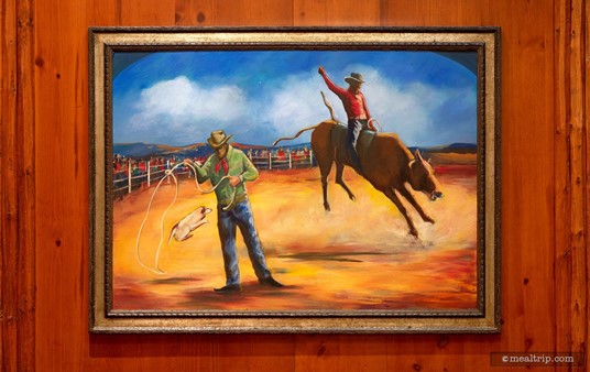 This great rodeo scene captures the dusty old west, while also being a little playful. Notice the pup jumping through the lasso in the foreground. Herding dog tricks were a fun part of any rodeo back in the day.