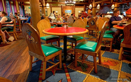 Here's a closer look at one of the tables at the Whispering Canyon Cafe. Most of the tables have a red surface that's lacquered. The chairs are all wood, but the moderate amount of padding makes them comfortable. The pattered carpet really adds to the fun, old-school, toy box feel of the restaurant.