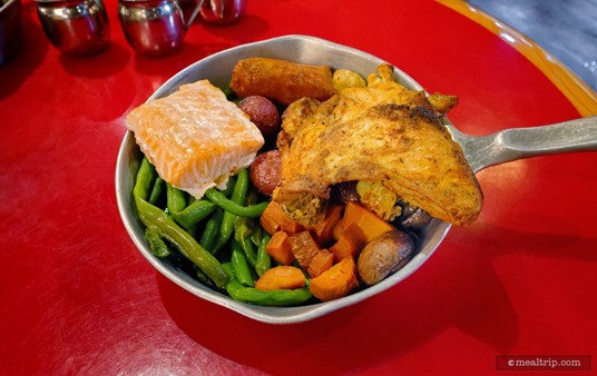 The Land and Sea Skillet includes house-smoked salmon, citrus-herb chicken, spicy vegan sausage, charred portobella mushrooms, barbecued cauliflower, roasted potatoes, sautéed green beans, and oven-roasted carrots.