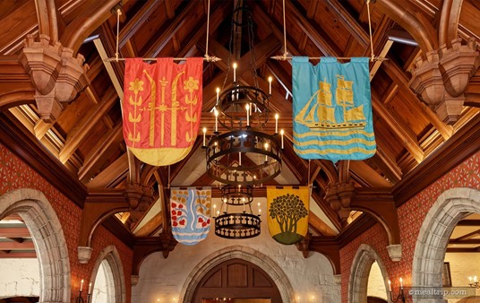 Royal crest flags and chandeliers hang from the tall wood ceiling at Akershus Royal Banquet Hall in Epcot's Norway pavilion.