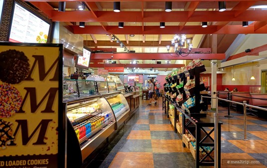 This is the food ordering line at the Earl of Sandwich shop in Orlando. You order your sandwiches, pretty much right where I'm standing to take this photo (there's a cast member just behind that sign on the left)... and then you walk down the line, picking up chips and cookies, etc... and then pay for your order down where that other guy is standing.