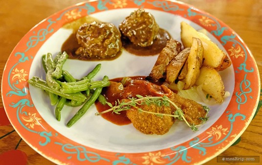 A plate from Biergarten's lunch buffet, meatballs in a dark herb sauce, chicken schnitzel, roasted potatoes, and green beans.
