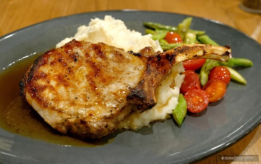The liquid on the left side of the pork chop is not au jus (per say), it's an apple cider reduction — and those mashed potatoes aren't just mashed potatoes either! They're infused with a hint of blue cheese.