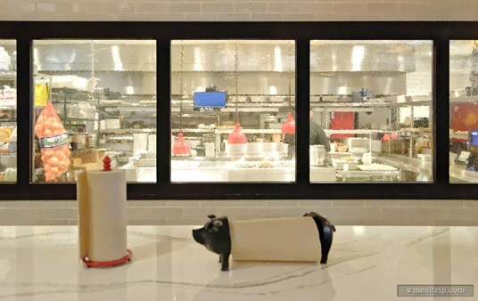 Here's a head-on view of the kitchen. Because you probably don't "really" want to see kitchen staff working on meat — there's a heavy distortion in the glass, that helps to hide any of the more violent parts of pulling meat off a pig.