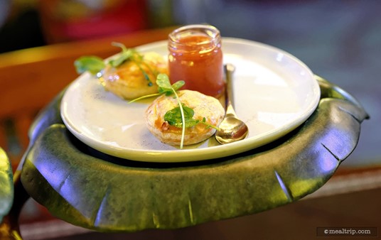 The Hunter's Pie (one per person) is a pastry shell filled with chicken. There's a very small jar of fruit preserves on the plate and a decorative green on each pie.