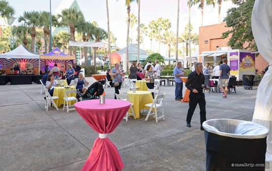 There are some seating and standing tables in the Carnival Corner area at the Food and Wine Classic. (2018)