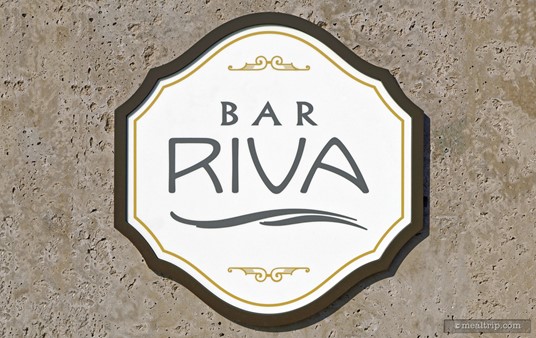 This main logo/sign for Bar Riva is located on an exterior column of the main structure of the resort. The lounge also has a blue "wave" logo badge, located on a wall, closer to the main entrance. Both seem to serve as logo/signs.