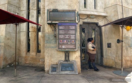 This is about as close to a "main entrance" as I could find for Docking Bay 7. The person standing outside the door isn't a "guard" or a "check-in" cast member, because you don't need reservations. I think this person's main purpose is to hand you a menu with prices on it so you can look at it before going in (the giant menu board in the middle doesn't include prices), and to keep the door closed. The "look" of the interior is more authentic, when there's not sunlight streaming in from the door.