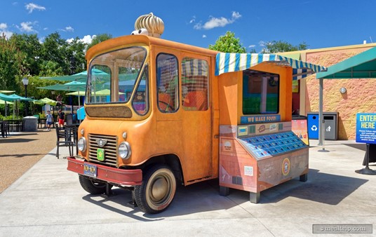 This mini orange truck is not a food ordering station, but a food-related game/activity, with a large computer screen and buttons.