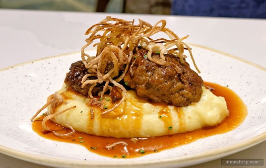 The Salisbury Steak is stated as being served with garlic-mashed potatoes, mushroom gravy, and fried onions.