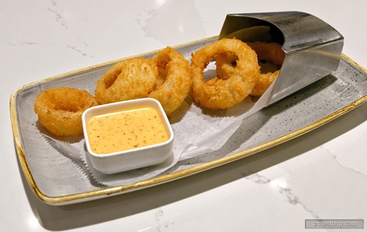 There were five onion rings on the Steakhouse 71 Onion Rings appetizer item. It's stated that the starter is served with a plant-based spicy ranch dipping sauce.