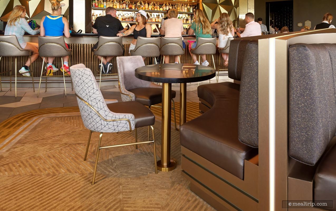 The guests sitting in the two chairs might have a sideways view of the main window looking out across Epcot – but guests sitting in the booths are pretty much going to be looking at the bar.