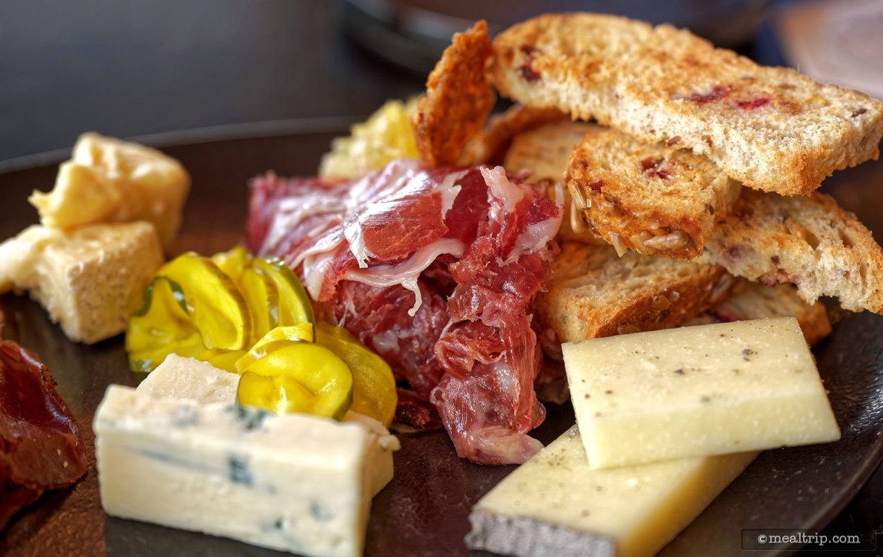 In the center of the photo is the Jamon Iberico (red meat/ham) surrounded by other elements on the Geo-82's charcuterie plate.
