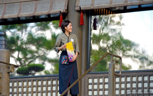 A cast member greets guests before entering Tokyo Dining.