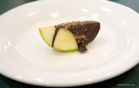 A chocolate covered apple slice with Butterfinger crumble.