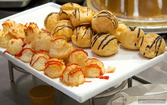 A collection of coconut macaroons with berry drizzle and small cream 
puffs with chocolate drizzle are on the dessert station at Hollywood and
 Vine.